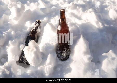 Deux bouteilles de bière brune froide dans la neige blanche fraîche dans le fond du soleil, hiver, neige, alcool, boisson concept copier espace Banque D'Images