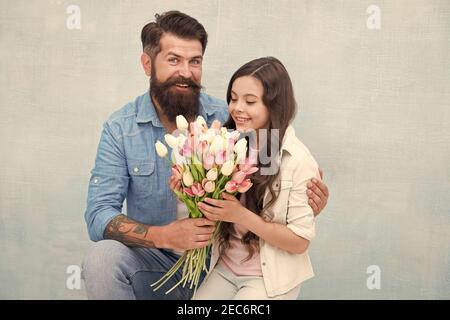 Fête d'anniversaire. Journée internationale de la femme. Fleuriste. Tradition familiale. Elle vaut tous les trésors. Tulipes tendre pour fille. Bouquet de tulipes d'homme. Père donnant des tulipes fille. Père avec fleurs. Banque D'Images