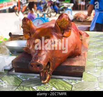 Tête de porc rôtie à la lumière du soleil sur la table du marché. Savoureux déjeuner de viande photo. Porc entier grillé. Plat traditionnel des Philippines. Image de Pinoy lechon. Outodo Banque D'Images