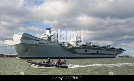 Vue du côté du port de la Marine royale, navire de guerre, le porte-avions HMS Queen Elizabeth, quitter Portsmouth, Royaume-uni le 2/2/18 avec MOD escorte de police bateau. Banque D'Images