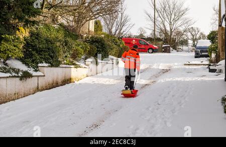 Royal Mail postman livrant des colis et des lettres dans la poste à l'aide d'un traîneau dans la neige, East Lothian, Écosse, Royaume-Uni Banque D'Images