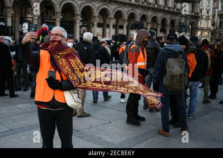 Milan, Italie. 13 février 2021. Un supporter des gestes du mouvement Orange Vêtes (Gilet Arancio) lors d'un rallye sur la Piazza Duomo à Milan, Italie, le 13 février 2021 crédit: Piero Cruciatti/Alay Live News Banque D'Images