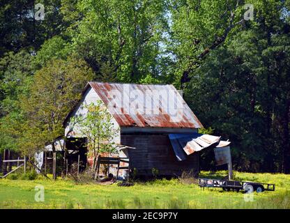 La grange située dans le sud de l'Arkansas est construite en bois avec une couche d'étain sur le dessus. L'étain rouillé et pauvre s'effondre. Banque D'Images