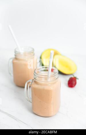 Milkshake aux fruits d'été avec mangue, banane et fraises Banque D'Images