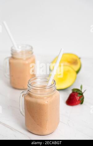 Milkshake aux fruits d'été avec mangue, banane et fraises Banque D'Images