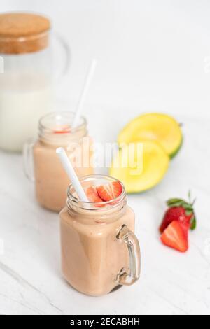 Milkshake aux fruits d'été avec mangue, banane et fraises Banque D'Images