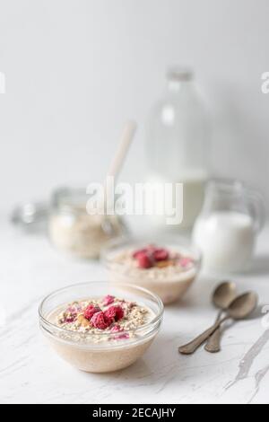 Avoine de nuit aux cacahuètes et aux framboises, petit déjeuner de porridge le matin, lait journal Banque D'Images