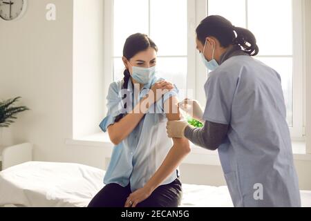 Le médecin prépare la main du patient pour l'introduction du vaccin contre le coronavirus. Banque D'Images