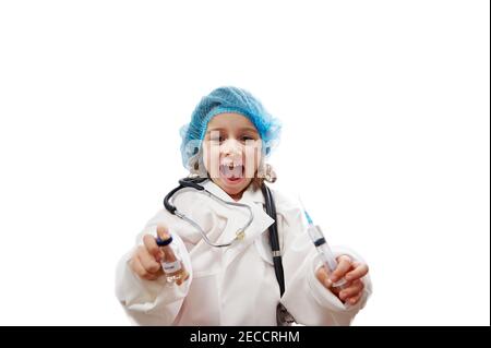 Portrait d'une petite fille mignonne avec stéthoscope en uniforme médical tenant un flacon de vaccin et une seringue. Concept de vaccination Banque D'Images