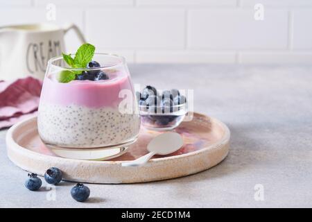 Pudding aux graines de Chia, yaourt aux myrtilles et baies fraîches en verre, préparé pour un petit déjeuner sain. Mise au point sélective. Banque D'Images