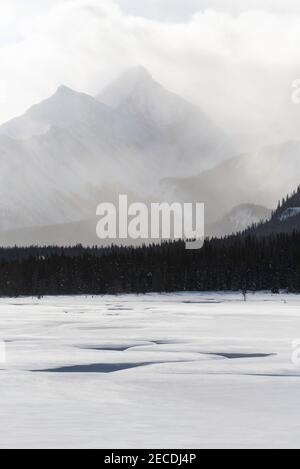 Une coupure dans la neige profonde se dirige vers la scène atmosphérique des Rocheuses canadiennes dans le pays de Kananaskis. Banque D'Images