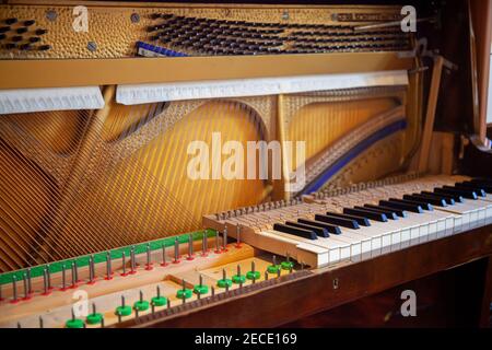 Piano vertical démonté pour réparation, entretien, réglage, nettoyage. Piano ouvert avec panneau sonore et chaîne visible. Banque D'Images