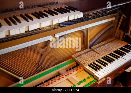 Piano vertical démonté pour réparation, entretien, réglage, nettoyage. Piano ouvert avec panneau sonore et chaîne visible. Banque D'Images