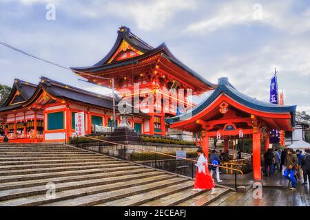 Moine habillé non reconnaissable dans le parc historique Inari autour de maisons traditionnelles japonaises - Kyoto ville. Banque D'Images