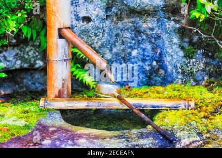 Tuyau d'eau potable et balancier japonais traditionnels dans le jardin japonais. Banque D'Images