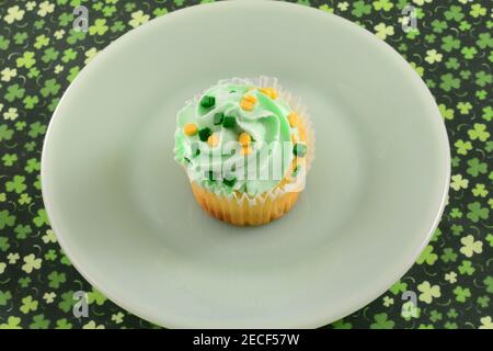 Saint Patrick's Day Cupcake avec verglas et saupoudrer assiette à dessert verte sur la nappe shamrock Banque D'Images