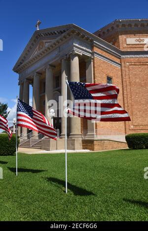 Les drapeaux américains flottent dans la brise devant la première église baptiste d'El Dorado, Arkansas. L'église montre le patriotisme le 4 juillet. Banque D'Images