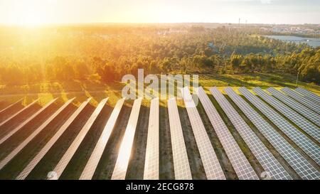 Vue aérienne de l'écologie centrale solaire panneaux ferme sur coucher ou lever du soleil Banque D'Images