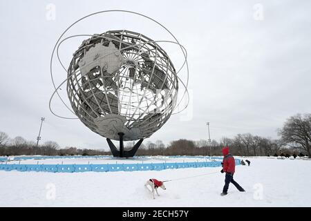 New York, États-Unis. 13 février 2021. Un homme marche son chien près de la fontaine Unisphere (construite pour l'exposition universelle de New York en 1964) pendant une journée d'hiver à Flushing Meadows Corona Park dans le quartier de New York City à Queens, NY, le 13 février 2021.(photo d'Anthony Behar/Sipa USA) crédit : SIPA USA/Alay Live News Banque D'Images