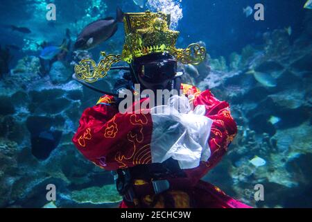 Kuala Lumpur, Malaisie. 10 février 2021. Un plongeur portant un costume traditionnel chinois god of fortune se produit à Aquaria KLCC pendant les célébrations du nouvel an lunaire. L'année de l'Ox d'or est célébrée dans une nouvelle norme par la communauté chinoise après la mise en œuvre de l'ordre de contrôle des mouvements (MCO) pour freiner la propagation de COVID-19 in Malaisie. Crédit : Lo Vivian/SOPA Images/ZUMA Wire/Alay Live News Banque D'Images