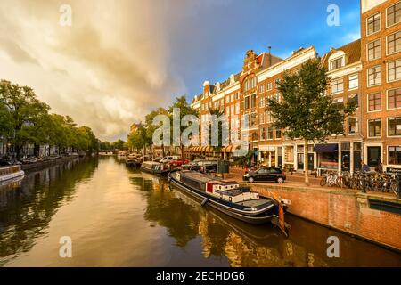 Une tempête automne approches cloud l'un des canaux intérieurs remplis de péniches dans le cercle intérieur historique Centre d'Amsterdam. Banque D'Images