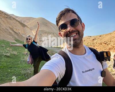 Couple de randonneurs prenant le selfie du haut de la montagne avec vue sur les sommets et la vallée en arrière-plan Banque D'Images