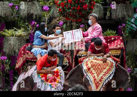 Pattaya, Chonburi, Thaïlande. 14 février 2021. Plusieurs dizaines de couples se sont réunis dans le parc du jardin tropical Noong Nooch de Pattaya pour se marier légalement lors d'une cérémonie de groupe le jour de la Saint-Valentin. Les couples attendaient leur tour pour grimper sur le dos des éléphants d'où ils recevraient leur nouveau certificat de mariage d'un responsable local également sur dos d'éléphant. Credit: Adryel Talamantes/ZUMA Wire/Alamy Live News Banque D'Images