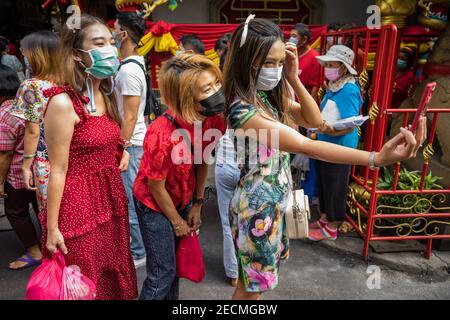 Les filles en masques de visage prennent un selfie sur Charoeung Krung Road, Bangkok pendant les célébrations du nouvel an chinois 2021 Banque D'Images