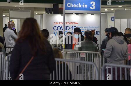 Les résidents locaux s'enregistrer pour recevoir une dose de COVID-19 au site de vaccination de masse de Cal Poly Pomona à Pomona, en Californie, le samedi 13 février 2021. Une femme de 78 ans est décédée de façon inattendue vendredi peu après avoir reçu la version Pfizer du vaccin COVID-19 au site Kaiser-RUN. La famille de la patiente a dit qu'elle avait des antécédents de maladie cardiaque. Sa cause de décès n'a pas encore été déterminée, mais le département de la santé publique du comté de Los Angeles a déclaré par courriel qu'il n'y avait aucun signe de réactions allergiques ou anaphylactiques. « sa mort ne semble pas liée au vaccin », a-t-il dit. Banque D'Images