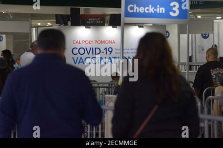 Les résidents locaux s'enregistrer pour recevoir une dose de COVID-19 au site de vaccination de masse de Cal Poly Pomona à Pomona, en Californie, le samedi 13 février 2021. Une femme de 78 ans est décédée de façon inattendue vendredi peu après avoir reçu la version Pfizer du vaccin COVID-19 au site Kaiser-RUN. La famille de la patiente a dit qu'elle avait des antécédents de maladie cardiaque. Sa cause de décès n'a pas encore été déterminée, mais le département de la santé publique du comté de Los Angeles a déclaré par courriel qu'il n'y avait aucun signe de réactions allergiques ou anaphylactiques. « sa mort ne semble pas liée au vaccin », a-t-il dit. Banque D'Images