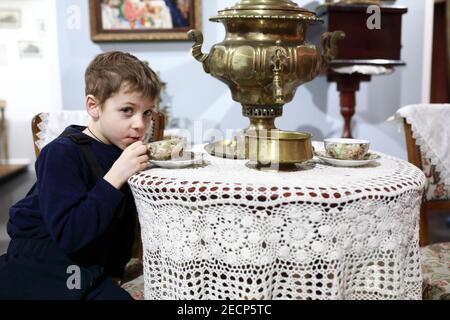 Un enfant boit du thé du samovar dans un café Banque D'Images