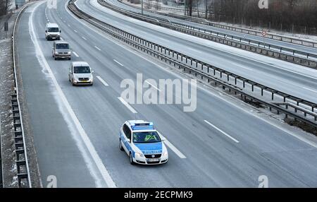 Kiefersfelden, Allemagne. 14 février 2021. Un véhicule de la police fédérale escorte les voyageurs rejetés sur l'autoroute A93 vide près de Kiefersfelden à la première sortie en Allemagne, de sorte qu'ils puissent tourner autour de là et de retour en Autriche. Des règles d'entrée allemandes plus strictes aux frontières avec la République tchèque et l'État autrichien du Tyrol pour se protéger contre les variantes dangereuses du coronavirus sont entrées en vigueur dimanche soir. Credit: Angelika Warmuth/dpa/Alamy Live News Banque D'Images