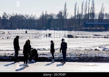 KINDERDIJK, PAYS-BAS - FÉVRIER 13: Les gens sont vus en train de profiter du patinage hivernal sur glace naturelle le 13 février 2021 à Kinderdijk, pays-Bas Banque D'Images