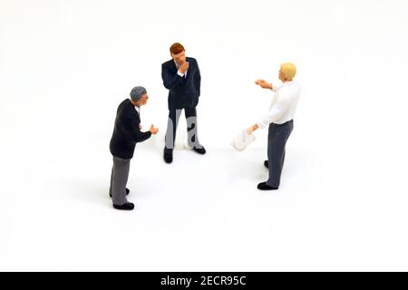 Homme d'affaires miniature sur fond blanc. Hommes d'affaires figurines macro photo. Réunion d'hommes d'affaires et présentation. Communication efficace. Competit Banque D'Images