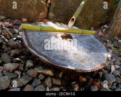 Un objet en bambou avec de la glace dans un jardin japonais, Tokyo. Banque D'Images