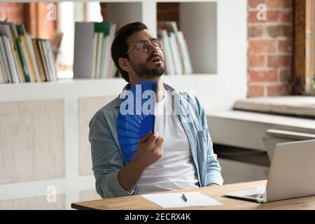 Vague d'employés de sexe masculin avec ventilateur à main Banque D'Images