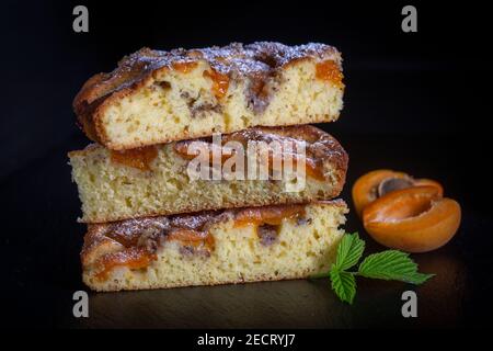 Tarte à l'abricot biologique maison prête à manger. Tarte à l'abricot avec noix sur fond noir, gros plan Banque D'Images