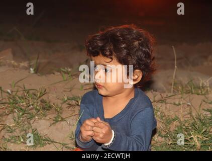 Une photo portrait de gros plan de beau petit garçon hindou jouant dans le jardin au coucher du soleil , enfant indien , petit garçon asiatique dans la nature Banque D'Images