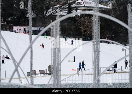 Varsovie. 13 février 2021. Les gens sont vus traîneaux sur une colline près de la vieille ville de Varsovie, Pologne, le 13 février 2021. Les prix et les ventes de traîneau en Pologne ont considérablement augmenté cette année en raison de la chute de neige importante qui n'a pas été observée depuis des années, ont rapporté les médias locaux. Credit: Jaap Arriens/Xinhua/Alamy Live News Banque D'Images