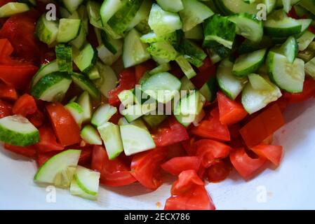 Légumes frais sains, petites tranches de concombres verts et tomates rouges pour la salade d'été, ingrédients pour la salade. Banque D'Images