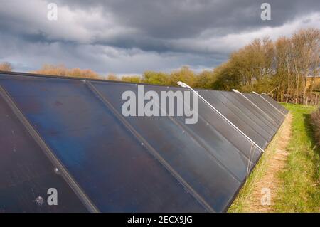 Panneaux solaires sur un champ près d'une centrale électrique dans Danemark Banque D'Images