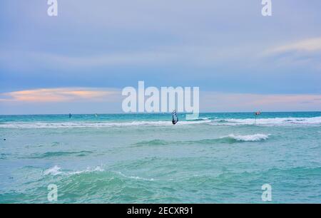 Hiver planche à voile, l'homme dans la combinaison de windsurfs en hiver, dans le fond lointain vous pouvez voir le bar de glace Banque D'Images