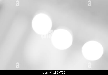 Un arrière-plan lumineux est allumé. Bokeh abstrait avec fond blanc. Un arrière-plan blanc brillant avec des cercles et des ovales. Modèle pour une carte de vacances. Banque D'Images