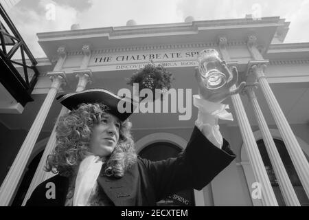 Balancier de printemps de Chalybeate en costume d'époque tenant un verre d'eau de source au printemps de Chalybeate, les Pantiles. Tunbridge Wells. Kent. Angleterre. ROYAUME-UNI Banque D'Images