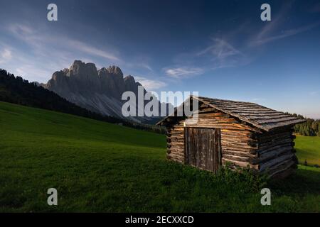 Clair de lune sur la montagne Odle groupe. Chalet en bois, prairies alpines. Nuit paysage de montagne. Les Dolomites de Funes valley. Alpes italiennes. L'Europe. Banque D'Images