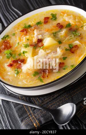 Soupe de choucroute polonaise recette Kapusniak dans l'assiette sur la table. Verticale Banque D'Images