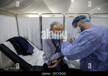 Beyrouth, Liban. 14 février 2021. Un membre du personnel âgé de l'hôpital Saint George reçoit une dose de vaccin contre le COVID-19 à Beyrouth, au Liban, le 14 février 2021. Le Liban a lancé dimanche sa campagne de vaccination en commençant par les employés du secteur de la santé après avoir reçu, un jour plus tôt, 28,500 vaccins de Pfizer-BioNTech, a rapporté la chaîne de télévision locale LBCI. Credit: Bilal Jawich/Xinhua/Alay Live News Banque D'Images