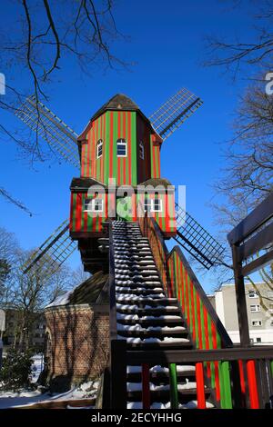 Viersen (Dulken), Allemagne - février 9. 2021: Voir au-delà des marches sur le moulin à vent rouge vert coloré rayé (Narrenmuhle) contre le ciel bleu en hiver Banque D'Images