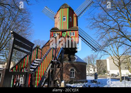 Viersen (Dulken), Allemagne - février 9. 2021: Voir au-delà des marches sur le moulin à vent rouge vert coloré rayé (Narrenmuhle) contre le ciel bleu en hiver Banque D'Images