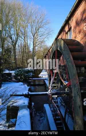 Wegberg (Holtmuhle), Allemagne - février 9. 2021: Vue sur l'ancien moulin à eau avec roue de lame à la crique avec neige en hiver Banque D'Images